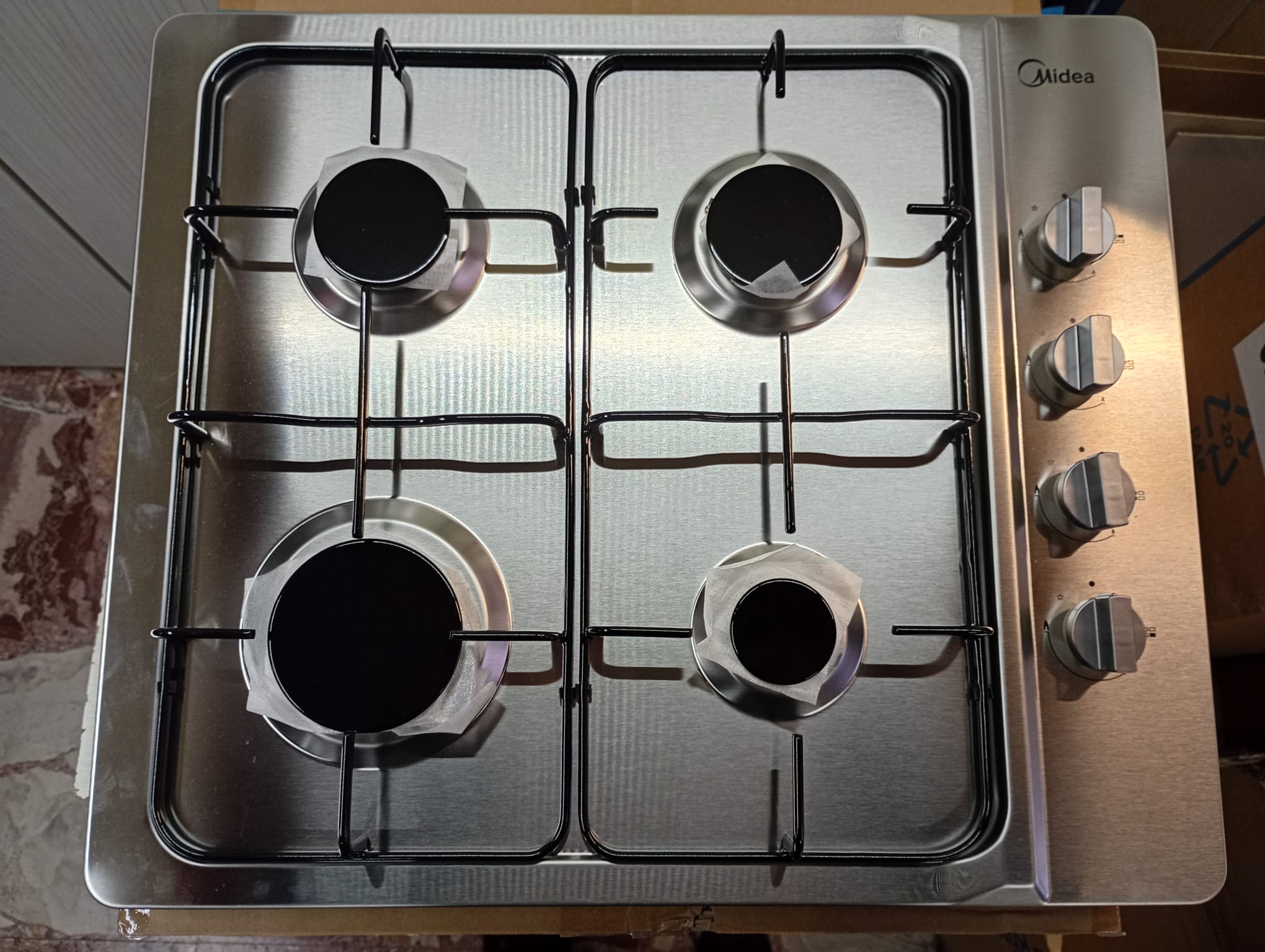 piano cottura midea con comandi laterali griglie smaltate con alvola sicurezza gas in acciaio inox satinato foto frontale